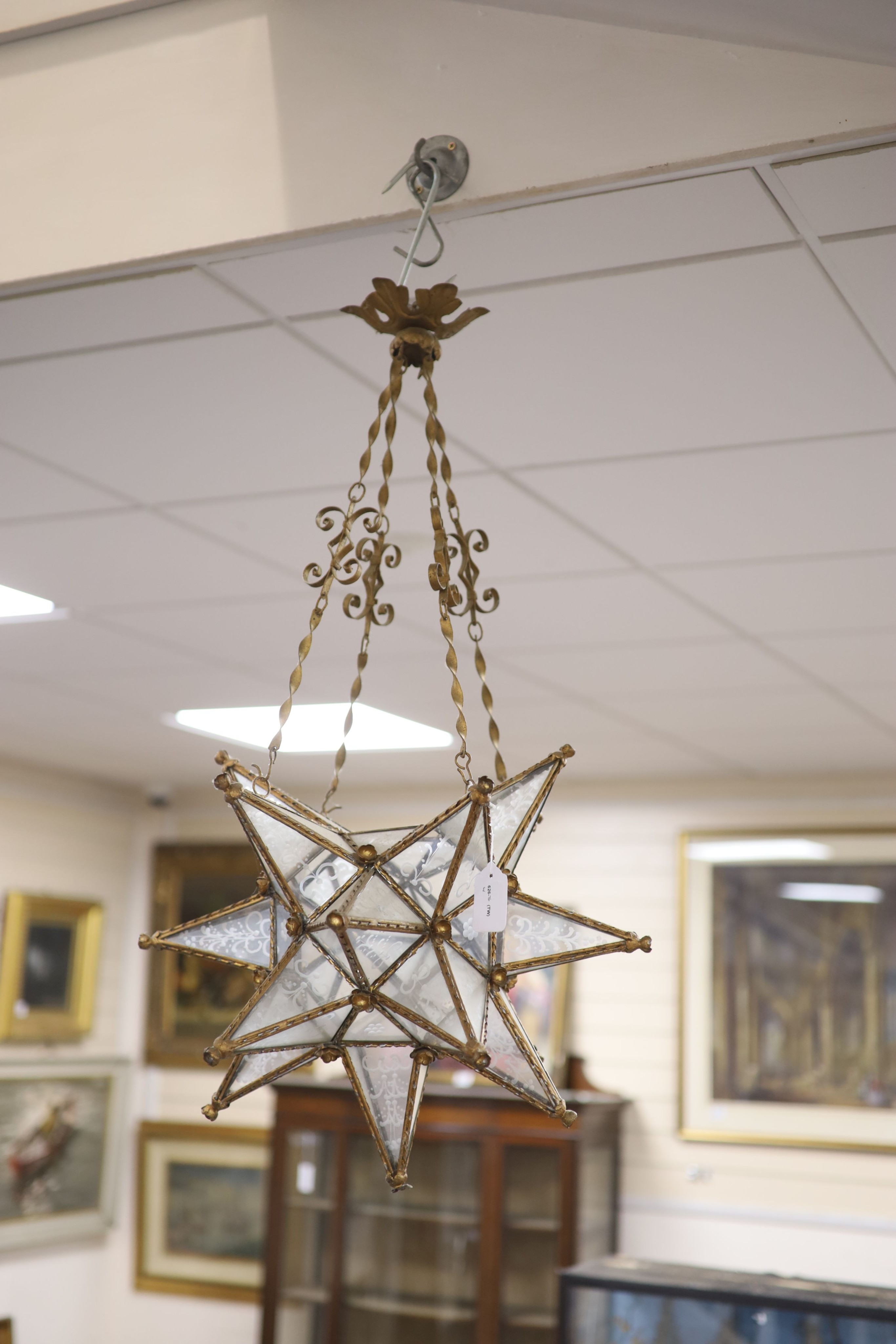 A gilt-metal star-shaped ceiling light, having etched plain glass panels and chain suspension, height 80cm